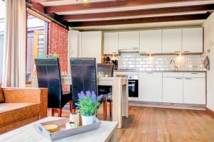 cocina y sala de estar con armarios blancos y mesa en Zeeuwse Rust Stavenisse, en Stavenisse