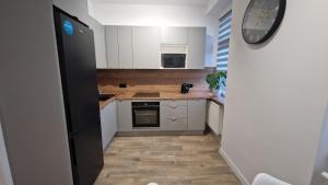 a kitchen with white cabinets and a black refrigerator at Apartament Przy Dworcu (centrum) in Tarnowskie Góry +4 photos