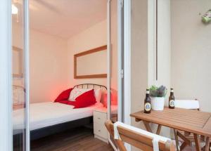 a bedroom with a bed with red pillows and a table at Apartament modern al carrer Blai, Poble Sec in Barcelona