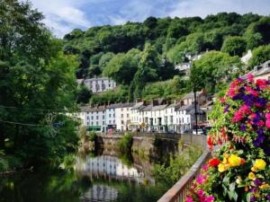 a town with flowers and a river with houses at Wards House Loft Apartment, Matlock in Matlock