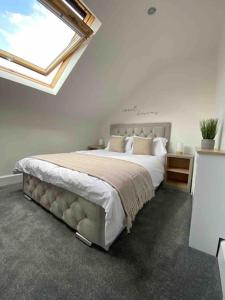 um quarto com uma cama grande e uma janela em Wards House Loft Apartment, Matlock em Matlock