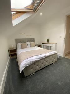 um quarto com uma cama grande e uma janela em Wards House Loft Apartment, Matlock em Matlock