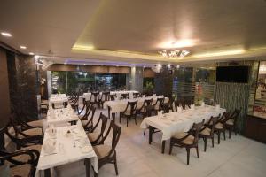 a dining room with white tables and chairs at Hotel Atulyaa Taj in Agra