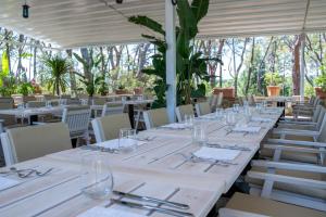un lungo tavolo con tavoli e sedie bianchi in un ristorante di Villa Cesi Resort & Spa a Impruneta
