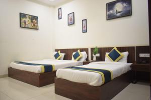 two beds in a hotel room with two at Hotel Lakshya Sheesh Mahal Indore in Indore