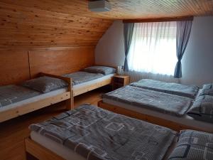 a room with three beds and a window at Chata Bohouš in Petrovice