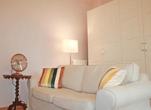 ein weißes Sofa im Wohnzimmer mit Ventilator in der Unterkunft Incantevole ed elegante appartamento a Niguarda! in Mailand + 12 Fotos