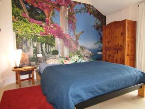 a bedroom with a blue bed and a window with flowers at Finca El Cardinal - Atemberaubende Luxusvilla in Icod de los Vinos