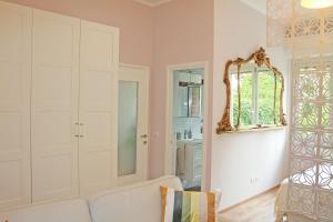 ein Wohnzimmer mit einem weißen Sofa und einem Spiegel in der Unterkunft Incantevole ed elegante appartamento a Niguarda! in Mailand