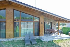 a house with glass windows and a table and chairs at Villa Letizia near the Bansko Ski Resort in Razlog