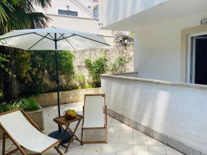a patio with two chairs and an umbrella at PaFi Apartment in Dubrovnik