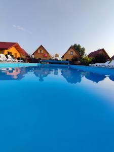 ein Pool in einem Resort mit Häusern im Hintergrund in der Unterkunft MIODOWA SADYBA Domki całoroczne in Ligota Zamecka