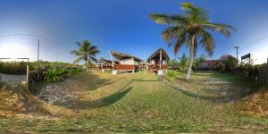 a house on the beach with a palm tree at Pousada Vettore in Atins