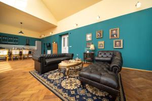 een woonkamer met lederen meubels en een blauwe muur bij Chateau Charme - Prague centre in Praag