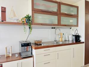 a kitchen with white cabinets and a sink at Penthaus Horizont mit Meerblick in Lübeck