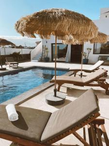 einen Pool mit 2 Liegestühlen und einem Sonnenschirm in der Unterkunft Villa Koa - Riders Surf n Bike in Roque