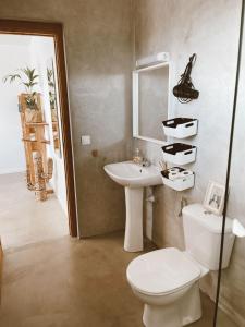 ein Badezimmer mit einem WC, einem Waschbecken und einem Spiegel in der Unterkunft Villa Koa - Riders Surf n Bike in Roque