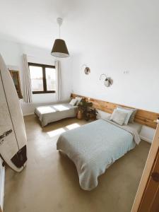 1 Schlafzimmer mit 2 Betten und einem Surfbrett in der Unterkunft Villa Koa - Riders Surf n Bike in Roque