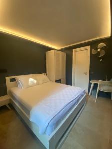 1 dormitorio con 1 cama grande con sábanas blancas en Life Butiq Otel, en Yalıkavak