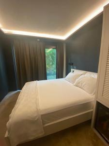 um quarto com uma cama branca e uma janela em Life Butiq Otel em Yalıkavak