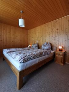 een slaapkamer met een bed in een houten kamer bij CHALET HÜTTLE - authentisch, ruhig, mitten im grün in Grächen