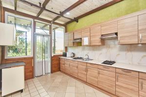 a large kitchen with wooden cabinets and a large window at Green guest house in Chornomorsk
