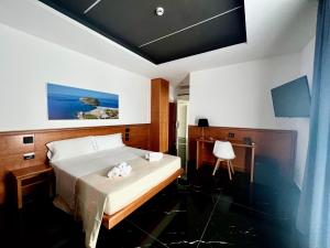 1 dormitorio con 1 cama con 2 toallas en Hotel TEA - Praia a Mare en Praia a Mare