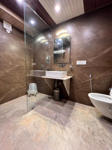 a bathroom with a sink and a glass shower at Hotel Victory in Shimla
