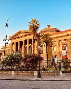 a large building with palm trees in front of it at Nigra Apartments in Palermo +22 photos