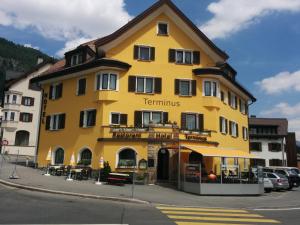 un edificio amarillo con un cartel. en Hotel Terminus en Samedan