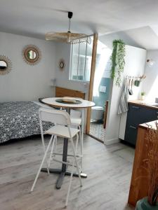 uma cozinha com uma mesa e duas cadeiras num quarto em Studio Le Refuge em Champ-sur-Drac