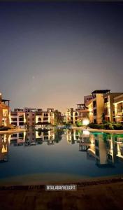 un reflet des bâtiments dans une masse d'eau dans l'établissement Marina apartment 2, à Aqaba