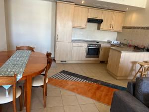 een keuken met een houten tafel en een eetkamer bij Marina apartment 2 in Aqaba