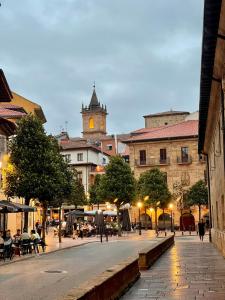 una calle de la ciudad con una torre del reloj en el fondo en Gonzalez del Valle, en Oviedo