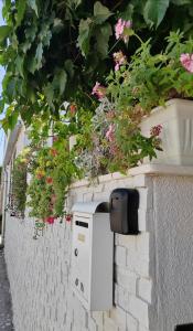 a mailbox on a brick wall with flowers at Apartman studio Otium in Pirovac