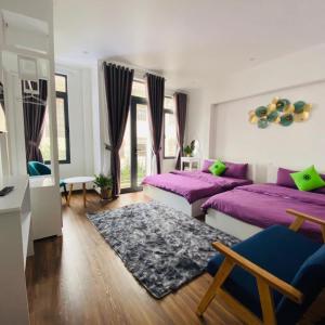 - une chambre avec 2 lits et des draps violets dans l'établissement WHITE COFFEE HOUSE HOTEL, à Đà Lạt