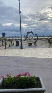 un parque con un banco y flores en la playa en Hotel Miami Beach, en Golem