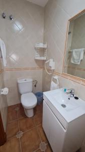 a bathroom with a white toilet and a sink at Hostal Canalejas in Cádiz