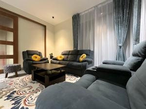 Sala de estar con 2 sofás y mesa en Golden Creeper, Luxe villa, en Kodaikanal