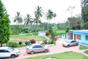 tres autos estacionados en un estacionamiento frente a una casa en Dharinidhama Homestay en SanivÄrsante