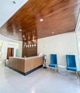 a lobby with two blue chairs and a reception desk at JRP Vanyard Resort Hotel in Kalibo