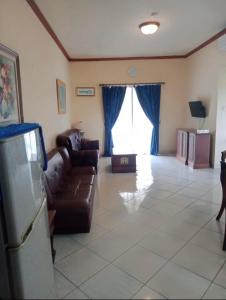 a living room with a couch and a large window at Apartment Marbella Anyer in Serang