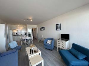 un salon avec des canapés bleus et une cuisine dans l'établissement Appartement Saint-Jean-de-Monts, 3 pièces, 4 personnes - FR-1-224C-89, à Saint-Jean-de-Monts