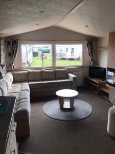 uma sala de estar com um sofá e uma mesa de centro em 48 Oak Village Grange Leisure Park em Mablethorpe
