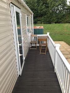 a deck with a table and chairs on a house at 48 Oak Village Grange Leisure Park in Mablethorpe