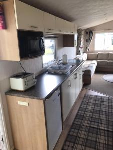 a kitchen and living room of a caravan at 48 Oak Village Grange Leisure Park in Mablethorpe