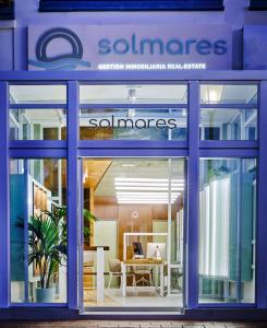 a store front with a blue facade with a glass window at Apartamentos Punta Canela in Isla Canela