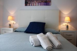 een slaapkamer met 2 handdoeken op een bed met 2 lampen bij Las Rosas in Vigo