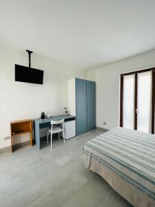 um quarto com uma cama, uma secretária e uma mesa em La Ringhiera em Novara