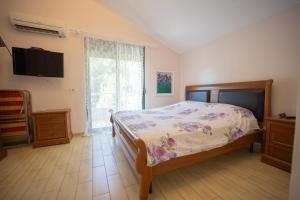 a bedroom with a bed and a flat screen tv at "Blue Bay Villa" at Gjiri Lalzit, Lalzi Bay, Lura 1 in Durrës